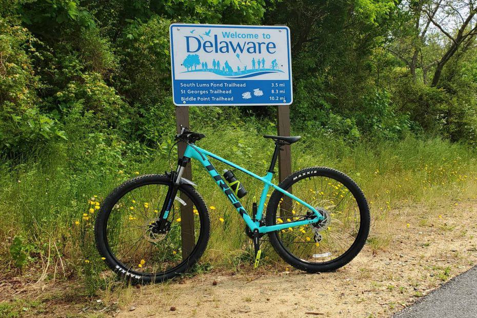 Delaware and Maryland State Line with bike in front of marker