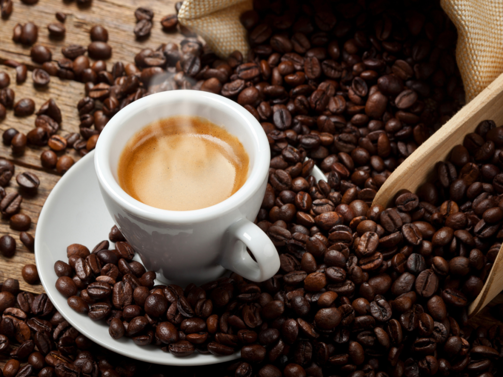 coffee beans and a white espresso cup and saucer