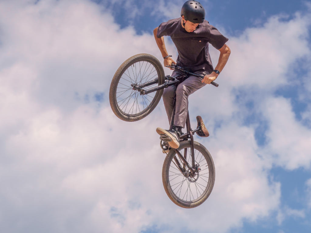 Bicyclist performing tric and wearing a multisport helmet