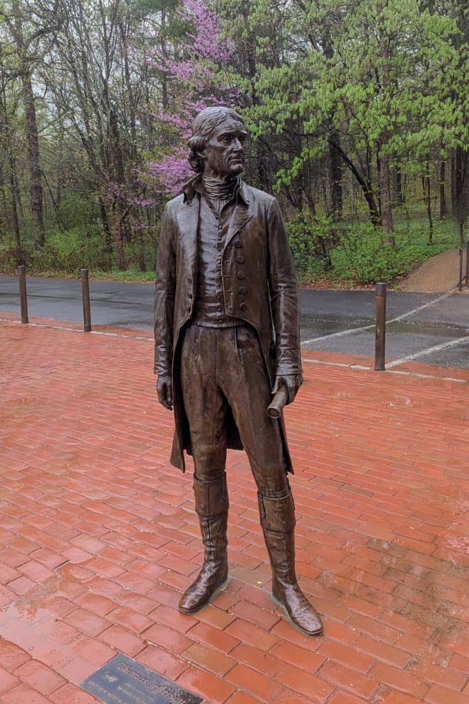A statue of Thomas Jefferson standing on a brick walkway.